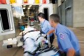 Paramedics loading patient into ambulance | Planos de Saúde United Class