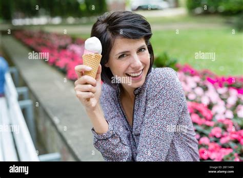 Laughing Woman Sits On Bench And Eats Ice Cream Stock Photo Alamy