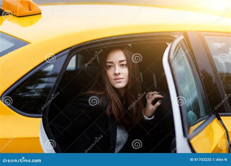 Young Brunette Girl In Backseat Of Taxi With Open Door Stock Image