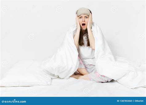 Fun Tired Young Woman Sitting In Bed With Sleep Mask Sheet Pillow Wrapping In Blanket
