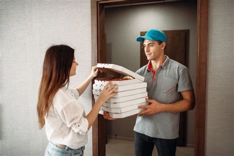 Premium Photo Delivery Man Shows Pizza To Customer At The Door