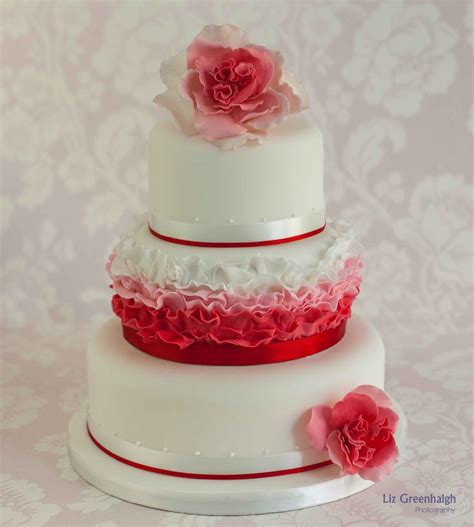 A Three Tiered Wedding Cake With Pink Flowers On Top