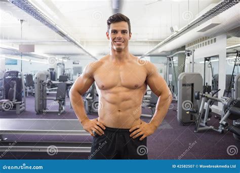 Smiling Shirtless Muscular Man With Hands On Hips In Gym Royalty Free