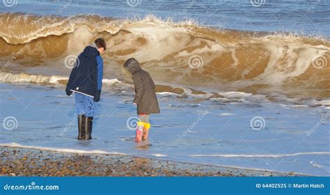 Children On Beach In Winter And Large Waves Editorial Image Image Of