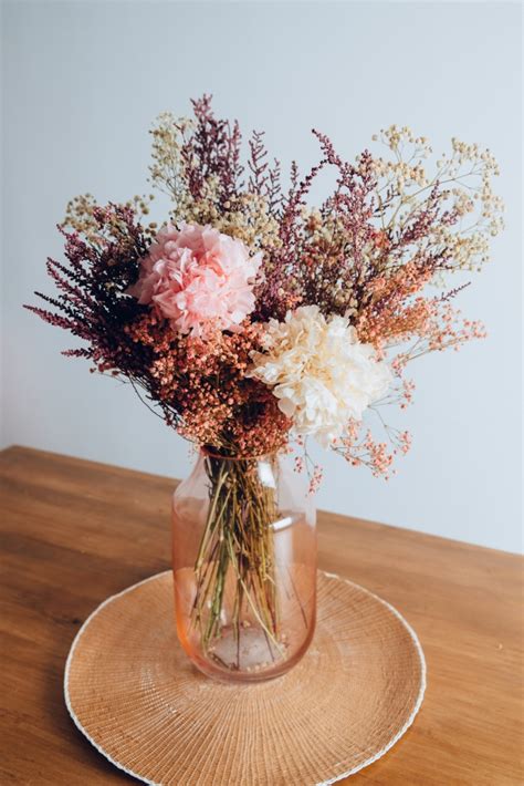 Jarrón de cristal con flores preservadas con hortensias y paniculata