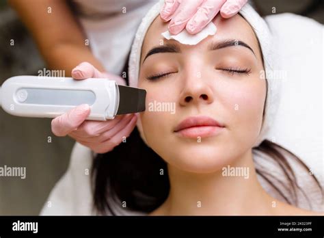 facial cleansing with ultrasound scrubber woman receiving ultrasound facial peeling and