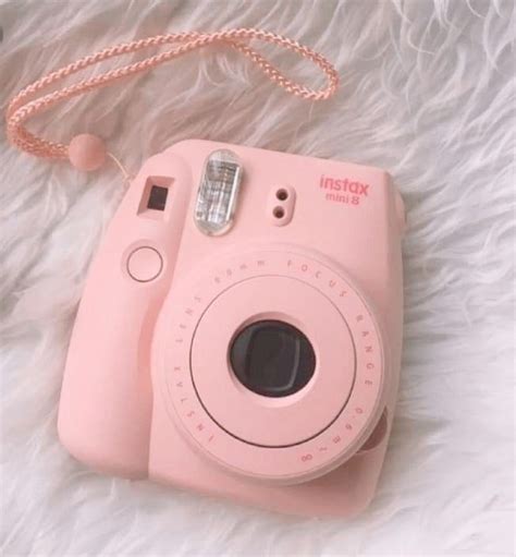 A Pink Camera Sitting On Top Of A White Blanket