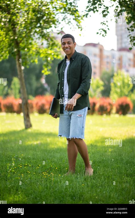 Man With Laptop Standing Barefoot On Grass Stock Photo Alamy