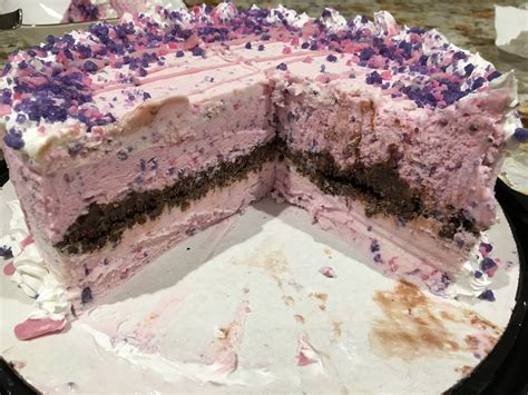 There Is A Large Cake With Pink Frosting On The Top And Purple