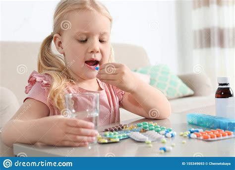 Little Child Taking Pill At Table Danger Of Medicament Intoxication