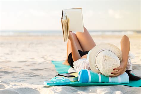Woman Lies On The Beach Reading A Book Fotografias De Stock E Mais