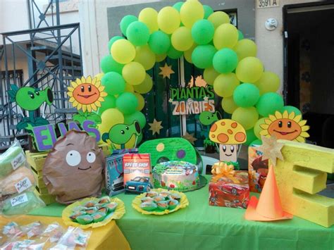 A Green Table Topped With Lots Of Food And Balloons In The Shape Of