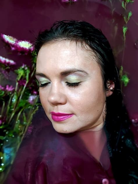 Fashion Interior Photo Of Beautiful Woman With Dark Hair Lying Naked In Petals Of Chrysanthemum