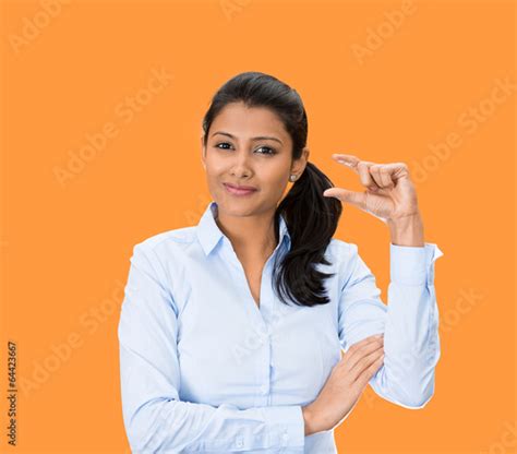 Woman Showing Small Size Hand Gesture On Orange Background Stock Photo