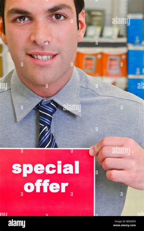Sales Clerk Showing A Special Offer Sign Stock Photo Alamy