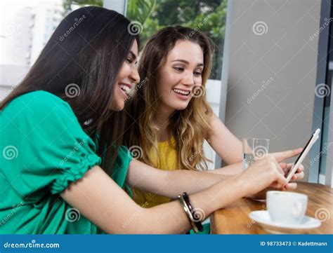 Two Adult Woman Looking At Pictures On A Phone Stock Image Image Of Happiness Looking 98733473