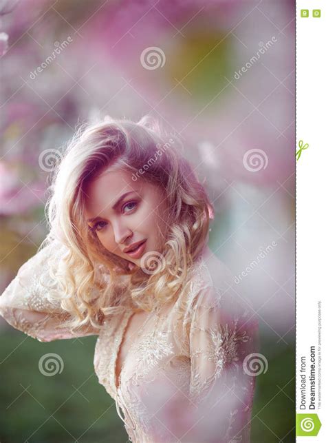 Beautiful Adult Girl Standing At Blossoming Tree In The Garden Stock