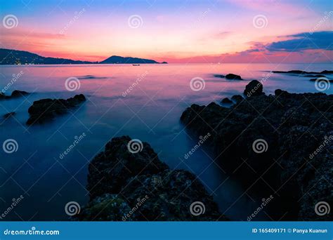 Long Exposure Image Of Dramatic Sky Seascape With Rock In The