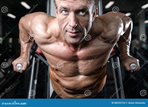 Brutal Strong Bodybuilder Man Pumping Up Muscles And Train Gym Stock