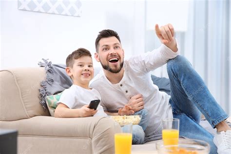 Padre E Hijo Viendo La Televisión En Casa Foto Premium