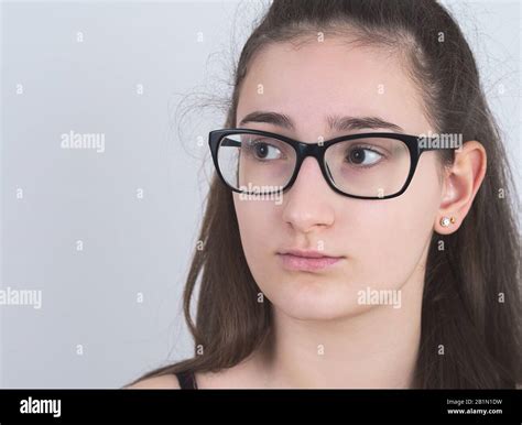 Portrait Of A Serious Bespectacled Long Haired Brunette Teen Girl Stock
