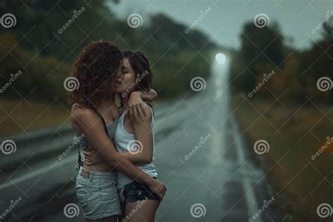 Lesbiennes De Filles Embrassant Sous La Forte Pluie Image Stock Image