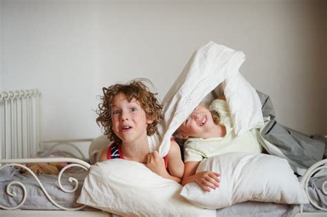 Zwei Kinder Bruder Und Schwester Geben Sich Auf Dem Bett Im Schlafzimmer Hin Stockfoto Bild