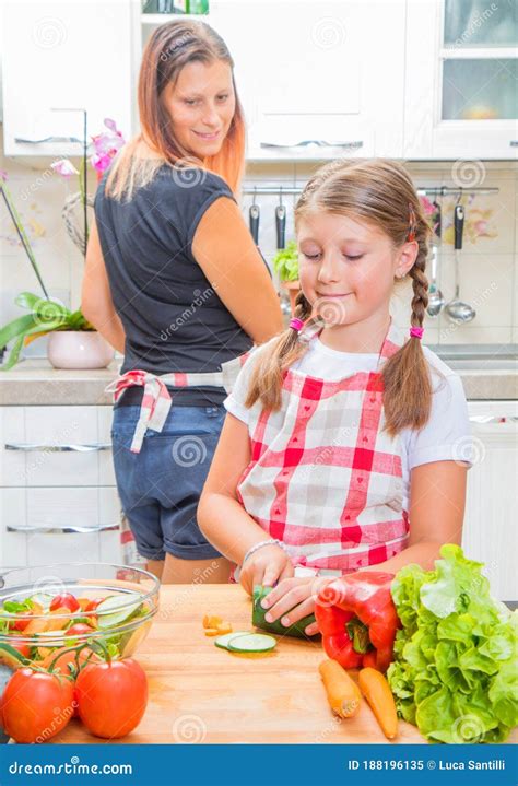 Mother And Daughter In Kitchen Are Preparing Vegetables Stock Image