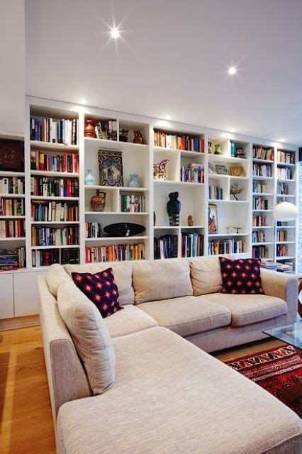 An Oversized White Bookcase With Additional Lights Take The Whole Wall