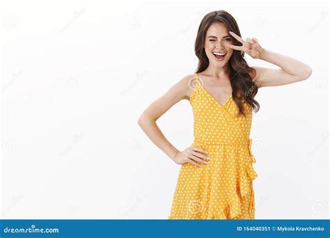 Ambitious Sassy Good Looking Female Model In Yellow Dress Wink Coquettish And Smiling Assertive