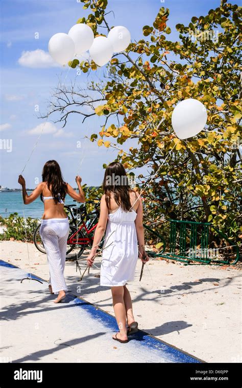 Two Teenage Girls Carrying Balloons To The Beach At Sanibel Florida Stock Photo Alamy