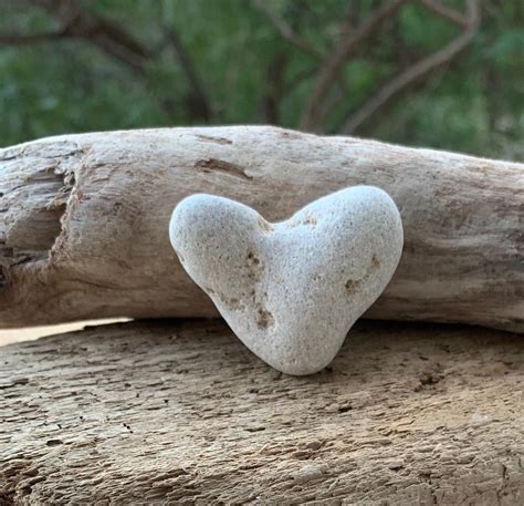 A Heart Shaped Rock Sitting On Top Of A Piece Of Wood
