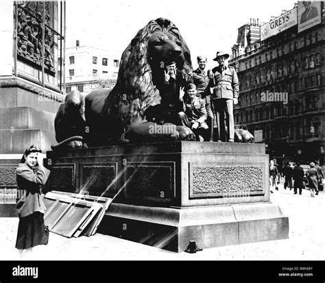 soldiers on one of the lions in trafalgar square during ww2 ve day victory celebrations stock