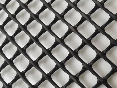 A Piece Of Black Plastic Mesh With Diamond Meshes On The White