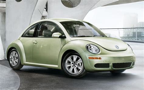 A Green Volkswagen Beetle Parked In Front Of A Building