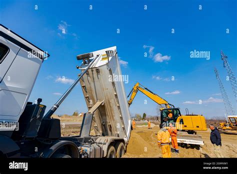 Dumper Truck Is Unloading Soil Or Sand At Construction Site Stock Photo