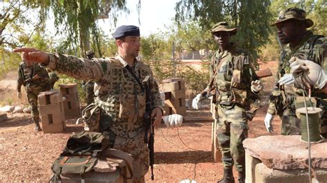 Ein soldat der bundeswehr steht mit einem sturmgewehr vom typ g36 am flughafen nahe des stützpunktes in gao im norden malis. Islamischer Staat: Kabinett billigt Bundeswehr-Einsatz im ...