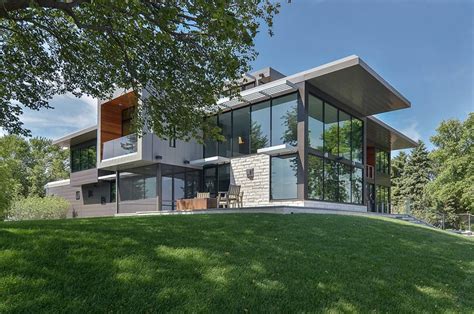 Glass Lake House Features Modern Silhouette Of Earthy Materials