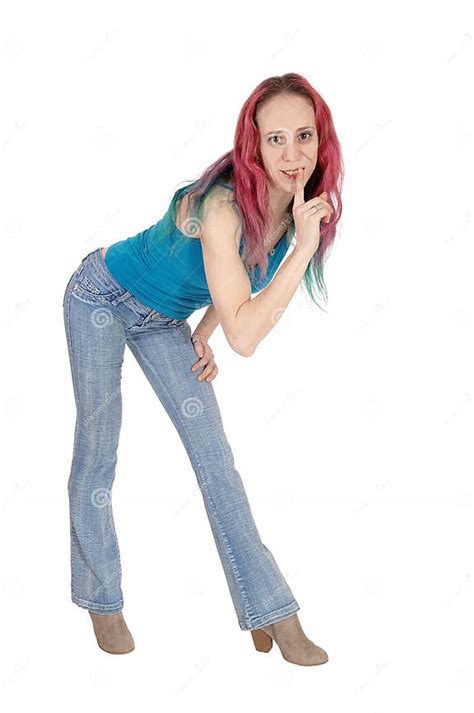 Woman Standing Bending Forward With Her Finger Over Mouth Stock Photo
