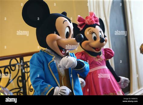 Entertainers Dressed In Mickey Mouse And Minnie Mouse Costumes Pose For