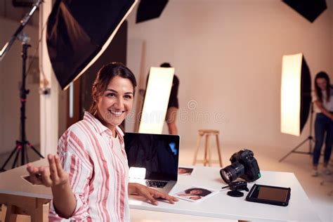 Portrait Of Professional Female Photographer Working In Studio With