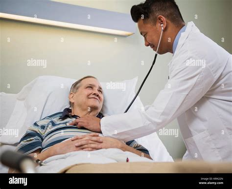 Doctor Listening To Chest Of Patient With Stethoscope Stock Photo Alamy