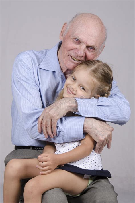 Portrait Of An Elderly Man Embracing A Granddaughter Royalty Free Stock