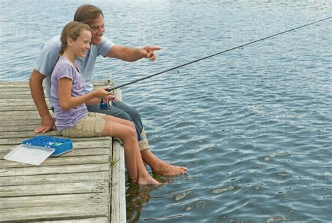 Father And Daughter Fishing Off Dock Stock Photo Dissolve