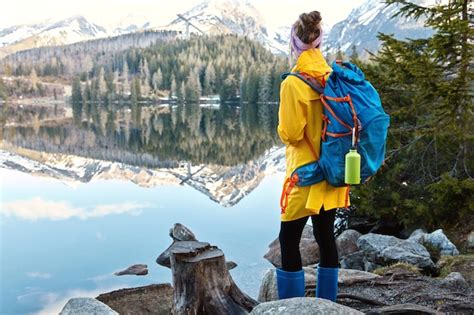 Free Photo Female Tourist Stands On Shore Of Beautiful Mountain Lake