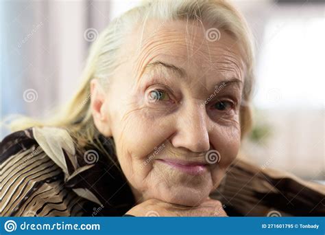 Smiling Portrait Of Happy Senior Woman Smiling And Sitting On Sofa At