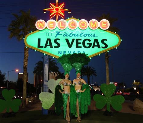 showgirls pose in front of the “welcome to fabulous las vegas” sign on