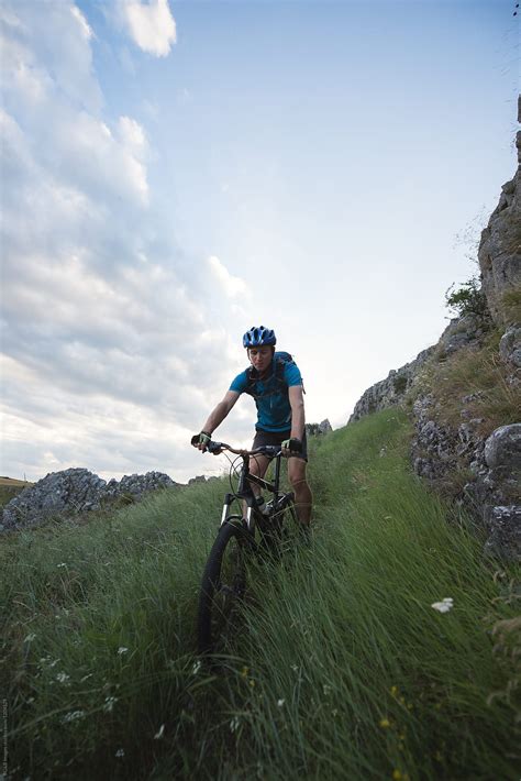 Cyclist Man Riding Mountain Bike Through A Tall Grass Meadow By Stocksy Contributor Ibex