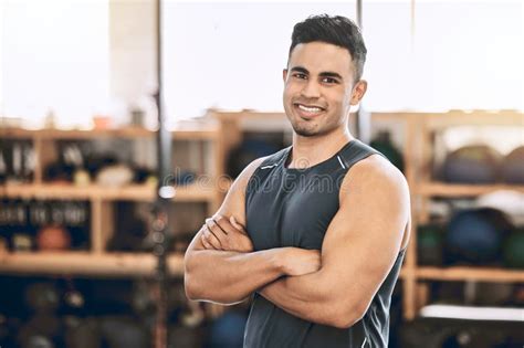 proud fitness trainer in his gym confident exercise coach in the gym indian fit man arms