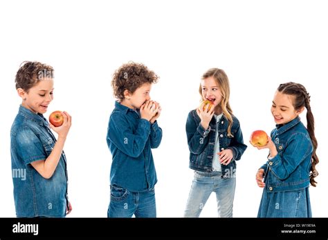 Four Kids In Denim Clothes Eating Apples Isolated On White Stock Photo